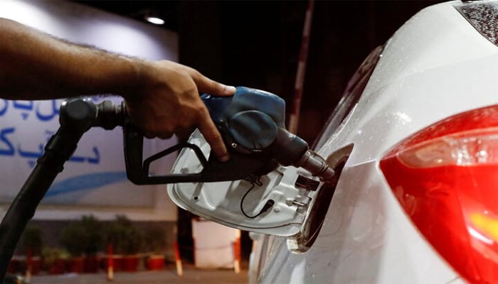 A worker holds a fuel nozzle to fills fuel in a car, after the government announced the increase of petrol and diesel prices, at petrol station in Karachi, Pakistan September 16, 2023. — Reuters